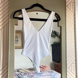 Babaton white v-neck bodysuit from Aritzia